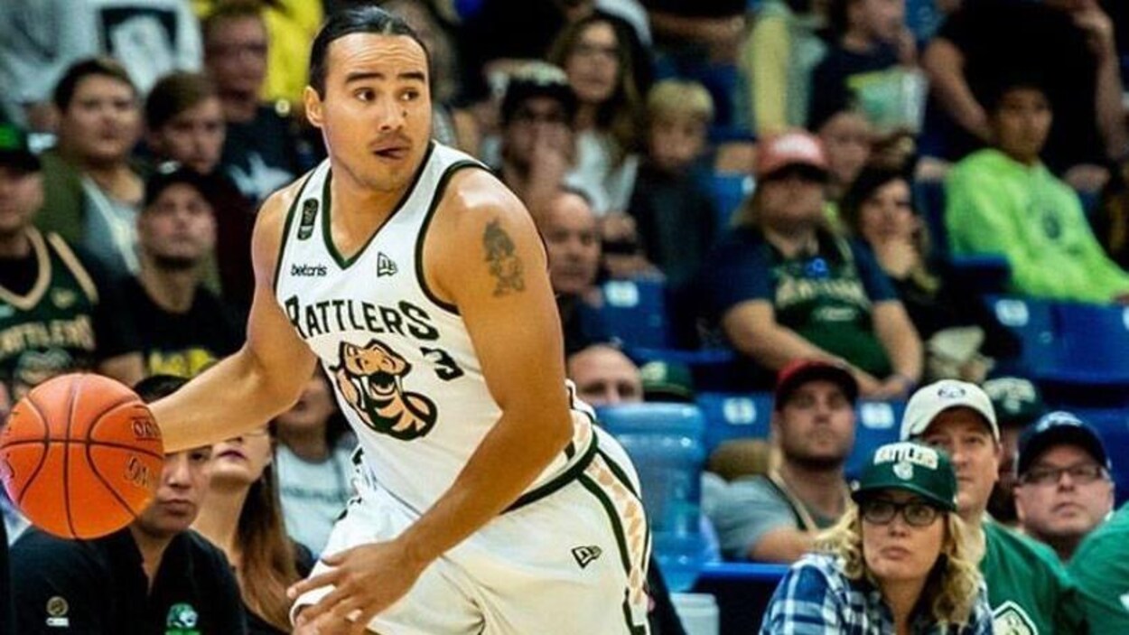 Michael Linklater en train de jouer sur un terrain de basket en maillot, le ballon à la main.