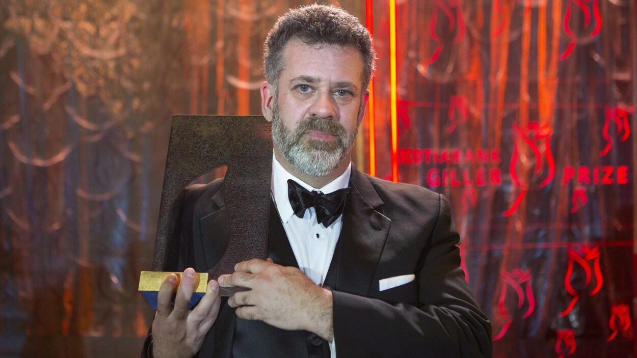 L'auteur Michael Redhill photographié avec un trophée après avoir remporté le prix Giller L'auteur Michael Redhill photographié avec un trophée après avoir remporté le prix Giller