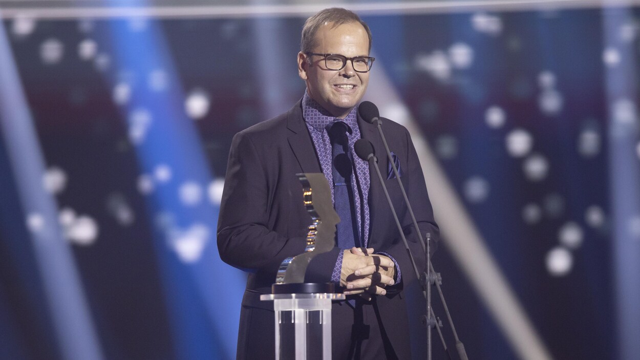 Michel Charette sur sa scène avec son trophée.