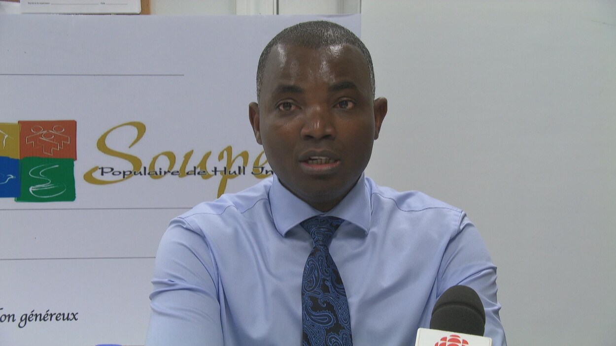 Un homme prend la parole en point de presse.
