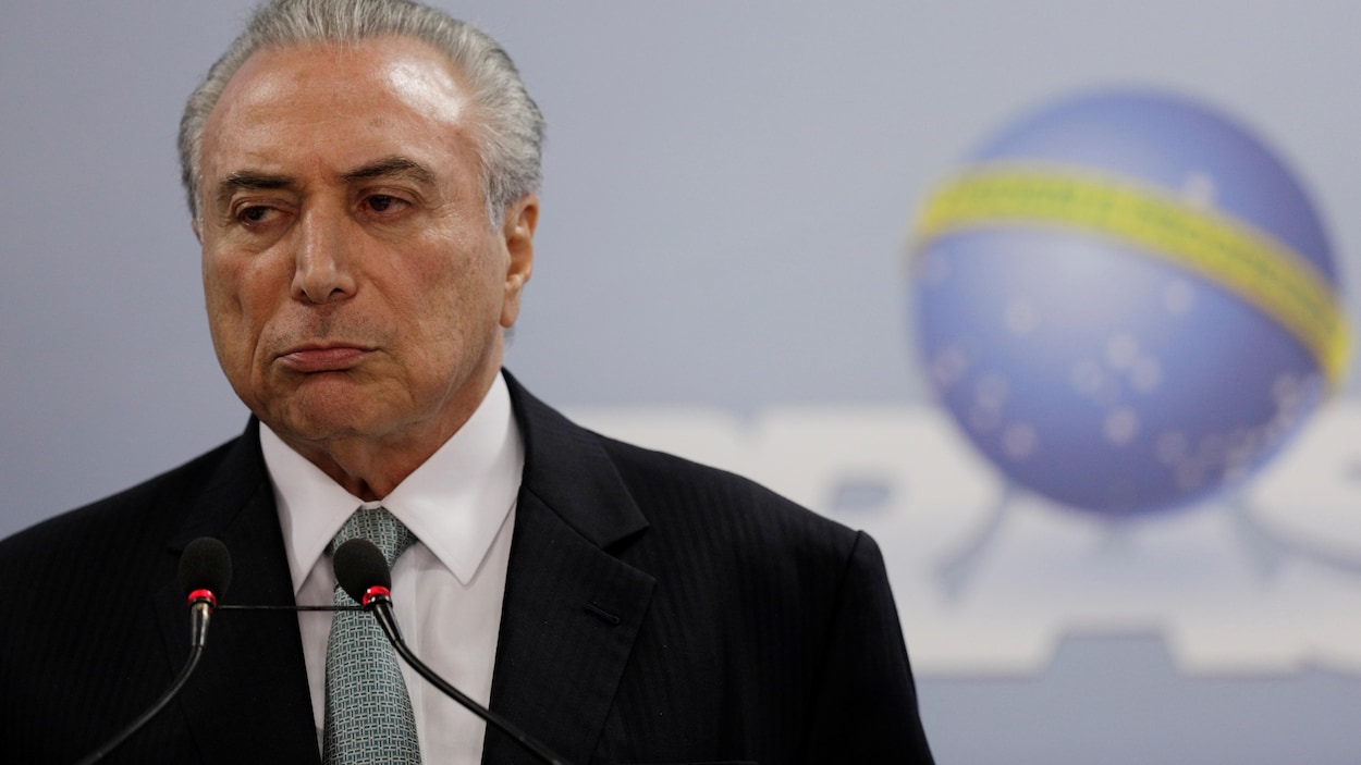 Le président brésilien Michel Temer, portant un veston noir et une cravate grise, ne semble pas heureux.