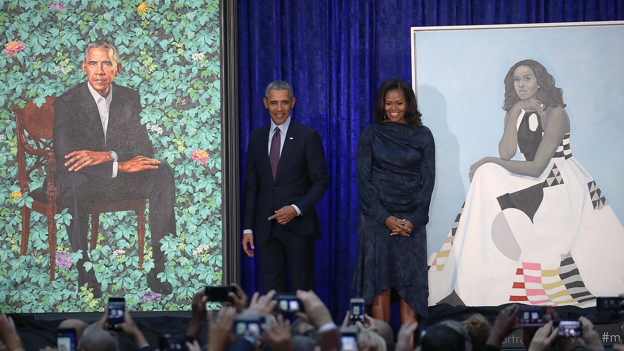 Barack et Michelle Obama prennent la pose, souriants, devant les portraits dévoilés à la National Portrait Gallery de Washington et pris en photo par de nombreuses personnes. Barack et Michelle Obama prennent la pose, souriants, devant les portraits dévoilés à la National Portrait Gallery de Washington et pris en photo par de nombreuses personnes.