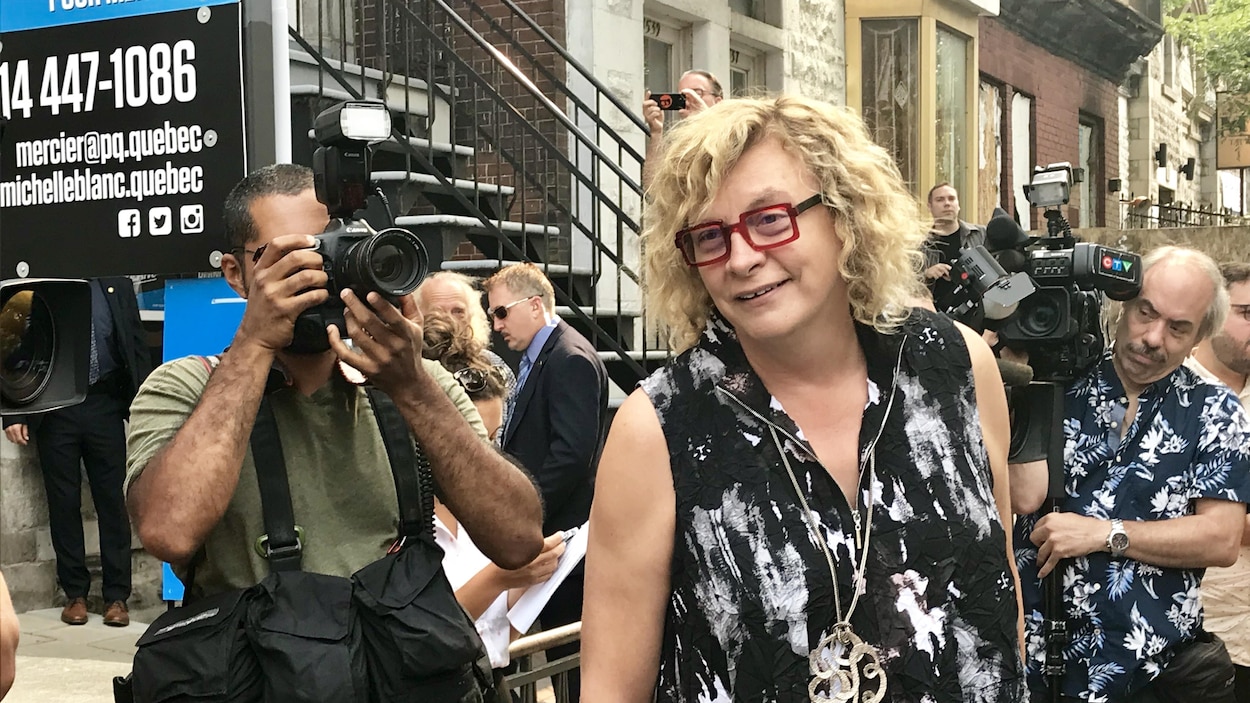 Michelle Blanc, entourée de photographes. Michelle Blanc, entourée de photographes.