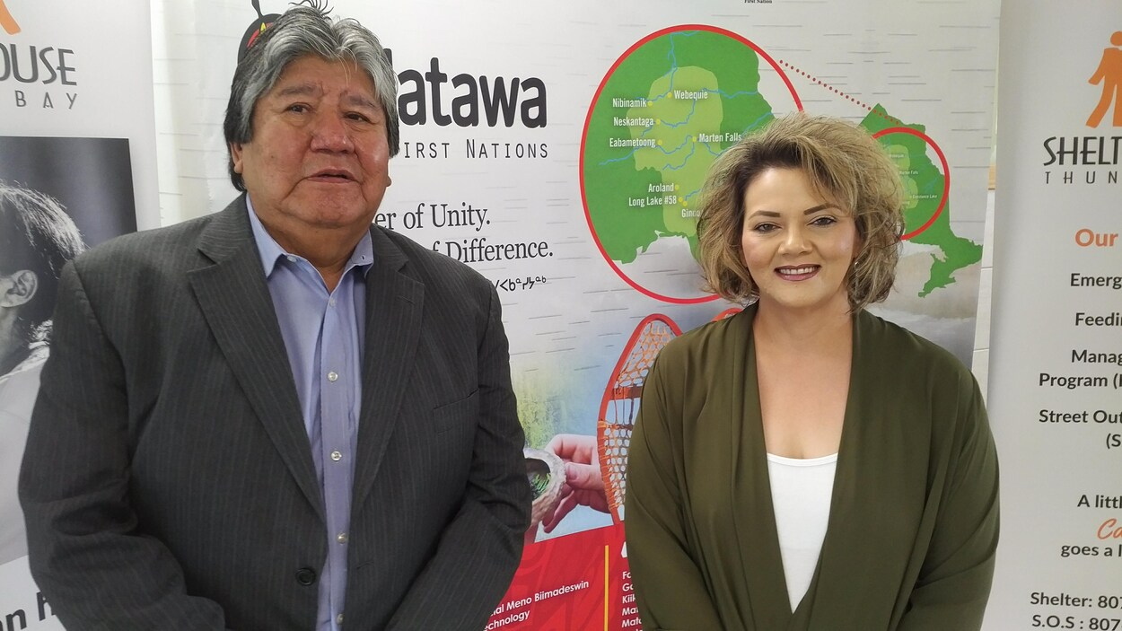 Le président-directeur-général de Matawa First Nations Management et la directrice générale de Shelter House de Thunder Bay pose devant une bannière. Le président-directeur-général de Matawa First Nations Management et la directrice générale de Shelter House de Thunder Bay pose devant une bannière.