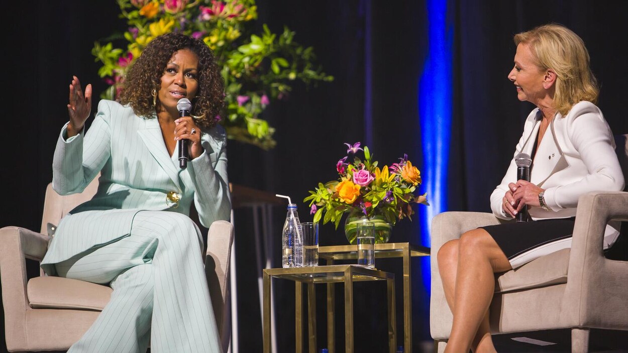 Michelle Obama sur une scène, assise avec un micro, aux côtés de Christiane Germain