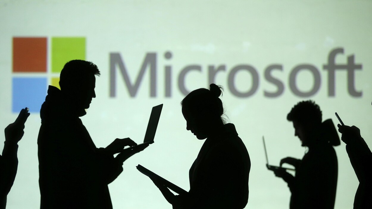Des silhouettes d'hommes et de femmes de profil avec des ordinateurs portables ou des téléphones mobiles entre les mains et, en arrière-plan, le logo de Microsoft. Des silhouettes d'hommes et de femmes de profil avec des ordinateurs portables ou des téléphones mobiles entre les mains et, en arrière-plan, le logo de Microsoft.