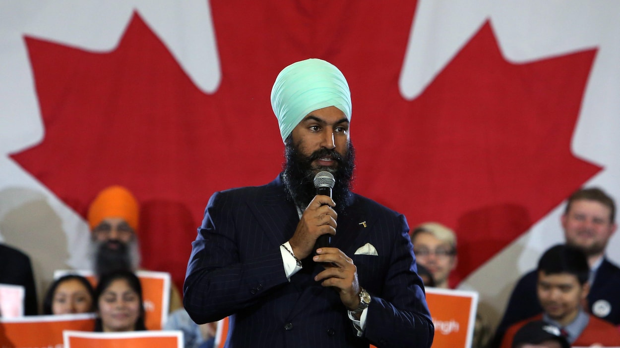 Jagmeet Singh prononce un discours devant le drapeau du Canada Jagmeet Singh prononce un discours devant le drapeau du Canada