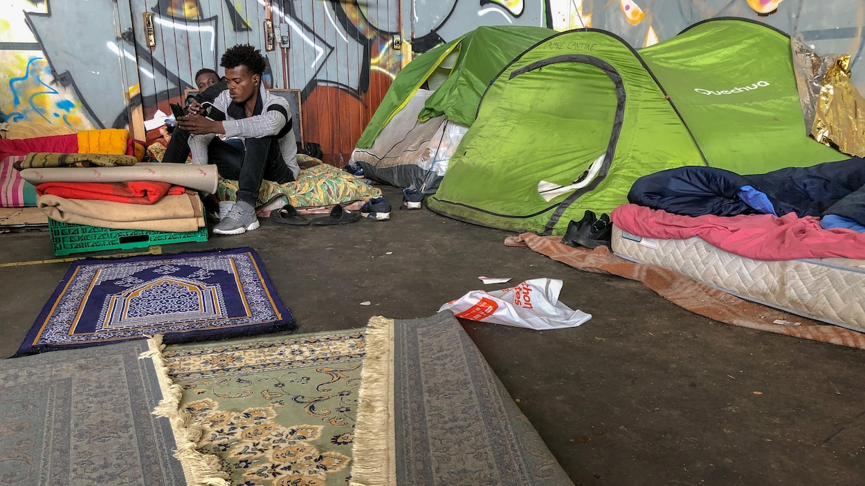 Deux hommes assis à travers des tentes et des tapis