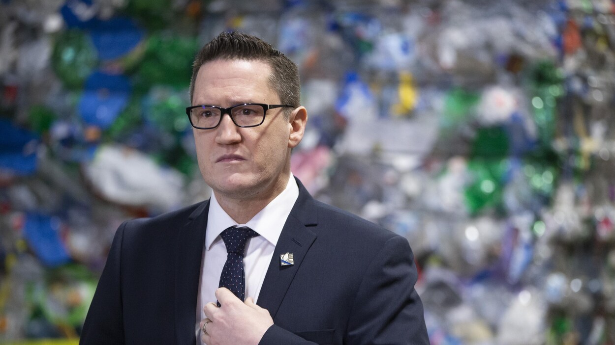 Benoit Charette devant des matières recyclables.