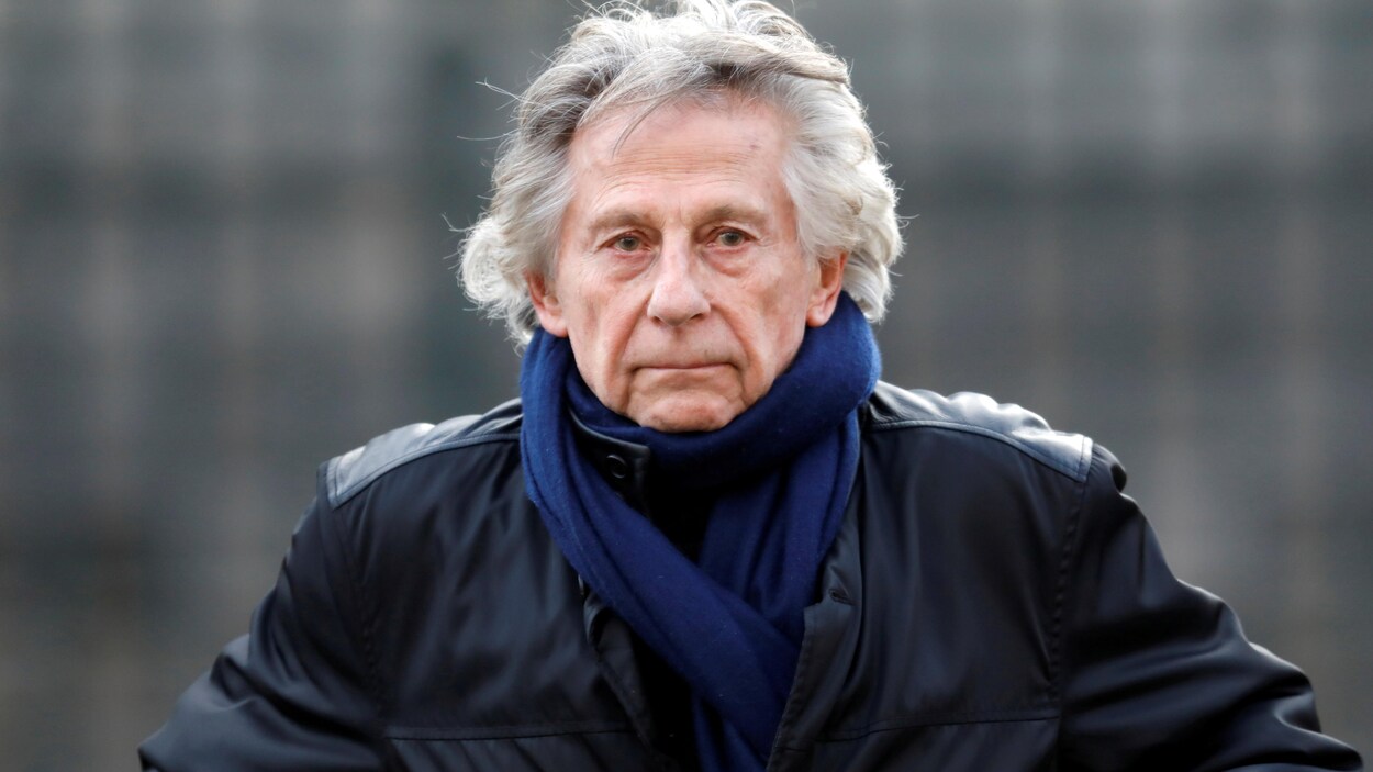 Photo de Roman Polanski vêtu d'un manteau de cuir, prise à l'extérieur.
