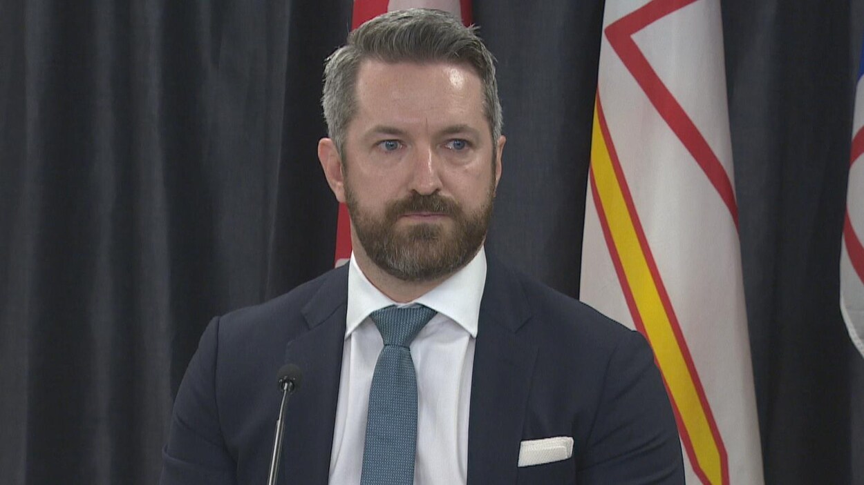 Mike King devant un drapeau de Terre-Neuve-et-Labrador.