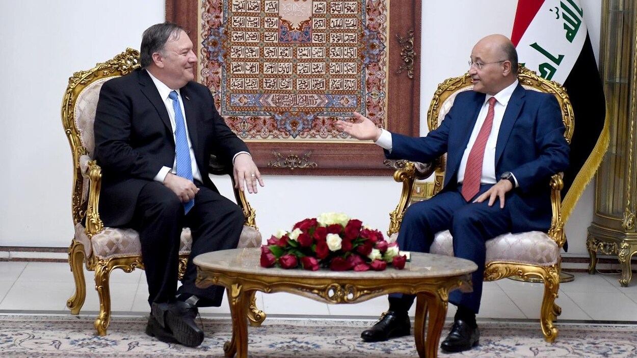 Mike Pompeo est assis en face de Barham Salih et l'écoute parler.