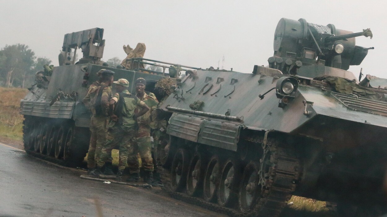 Des soldats sont à l'extérieur de véhicules militaires, près de Harare, au Zimbabwe, le 14 novembre 2017. Des soldats sont à l'extérieur de véhicules militaires, près de Harare, au Zimbabwe, le 14 novembre 2017.