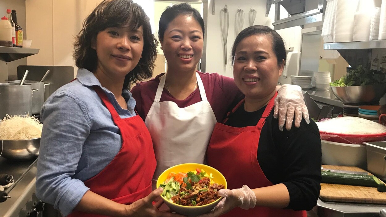 L'entrepreneuse Luanne Truong présente une salade typique du Vietnam, avec deux de ses employées.