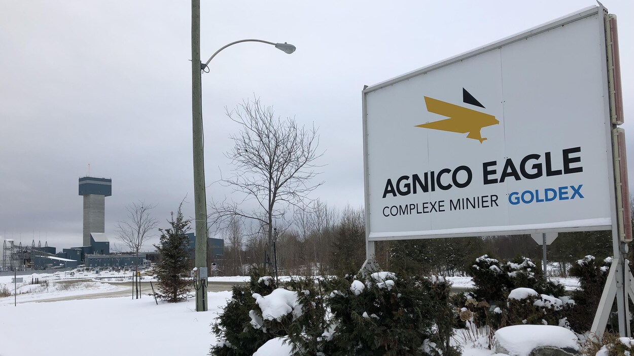 L'affiche à l'entrée du site minier Goldex, d'Agnico Eagle, avec la mine au loin.