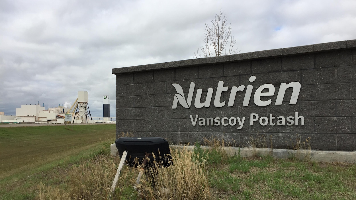 Au premier plan, l'enseigne de la mine Nutrien de Vanscoy et en arrière-plan les installations de la mine.