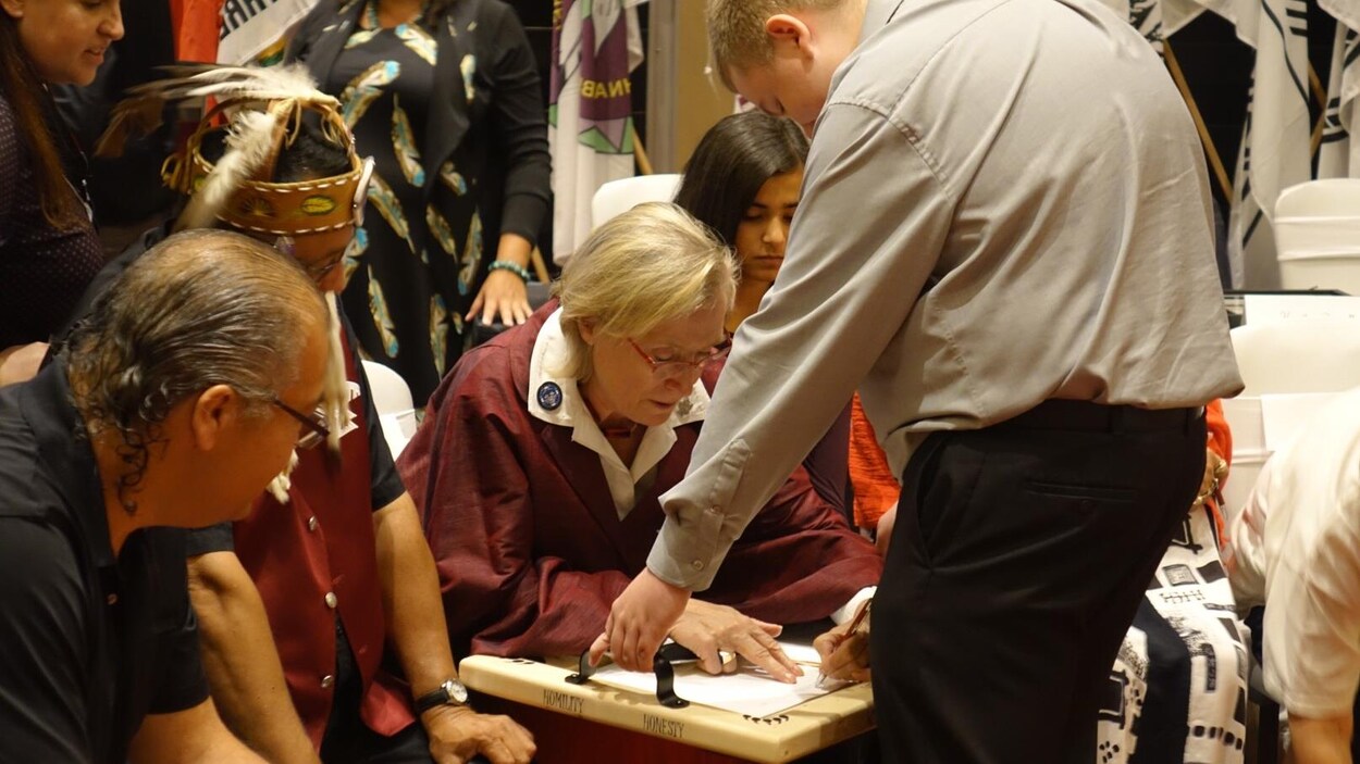 La ministre Carolyn Bennett en train d'apposer sa signature. La ministre Carolyn Bennett en train d'apposer sa signature.