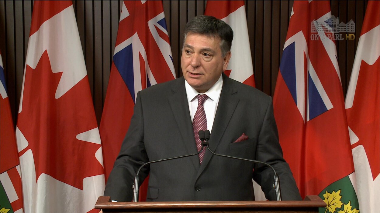 Charles Sousa parle à un podium.