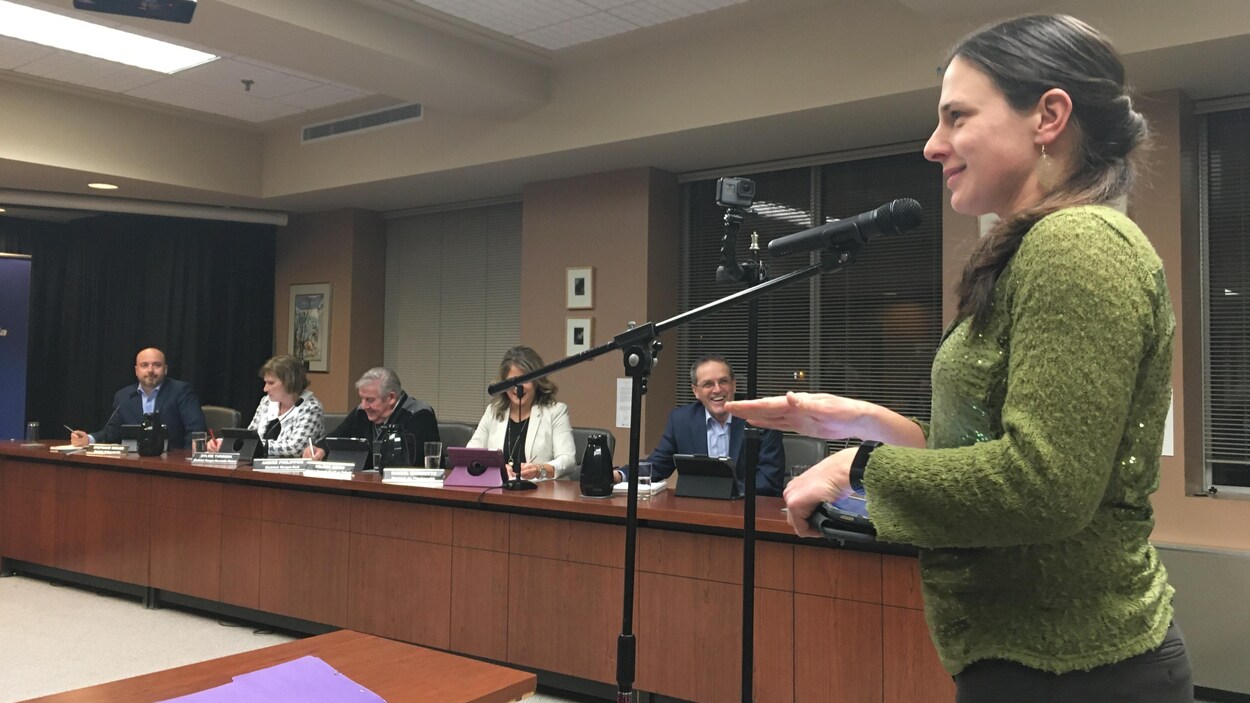 Une femme s'adresse au conseil municipal de Rouyn-Noranda, souriante.