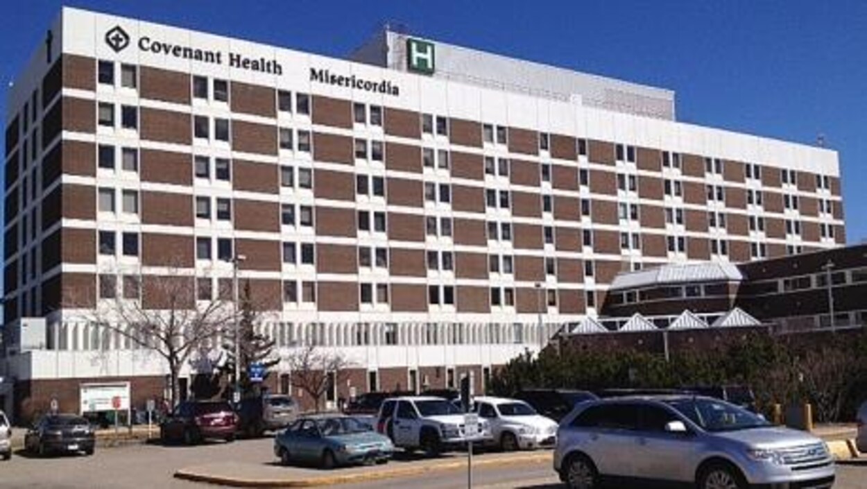 La façade de l'hôpital Misericordia et les places de stationnement devant ainsi que quelques voitures.
