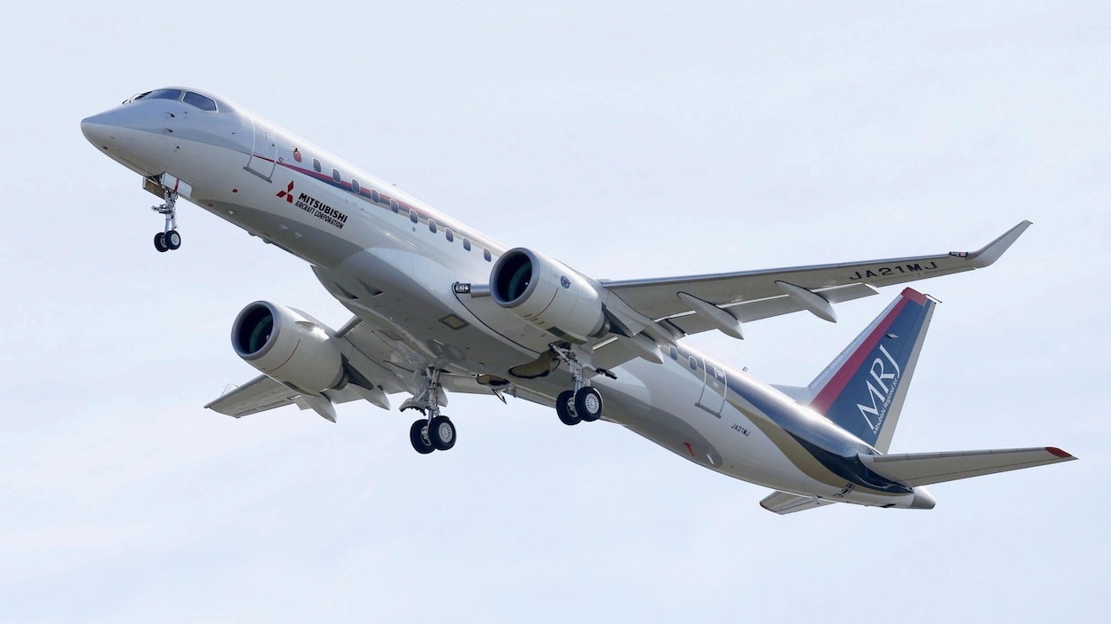 Un avion MRJ s'envole dans un ciel clair.