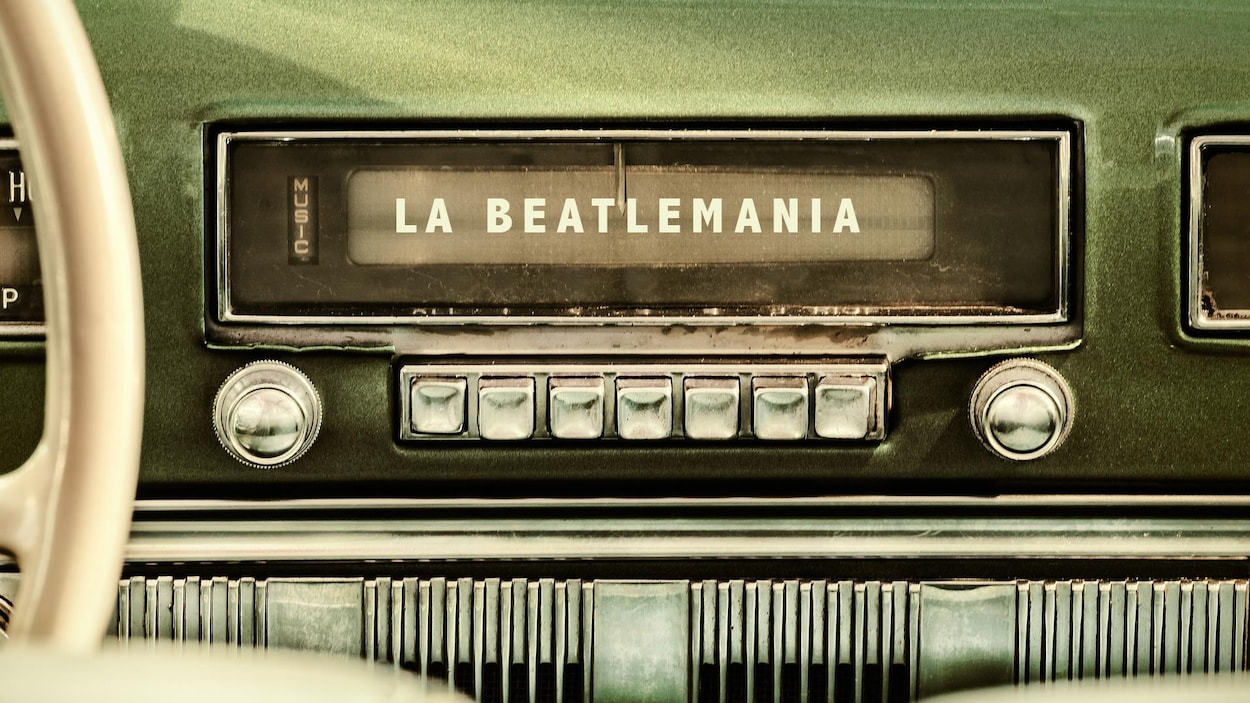 Une radio d'une vieille voiture avec la légende « La Beatlemania ».