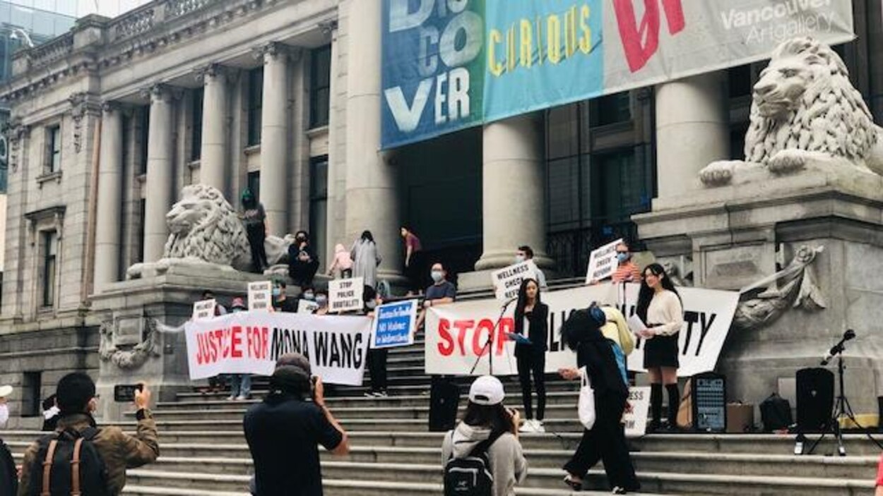 Des manifestants brandissent des banderoles sur les marches du musée.