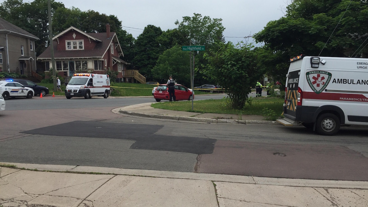 Deux ambulances et au moins trois véhicules des policiers sont garés le long de la rue
