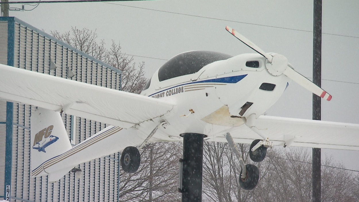 Un avion soulevé devant l'entrée du Moncton Flight College.