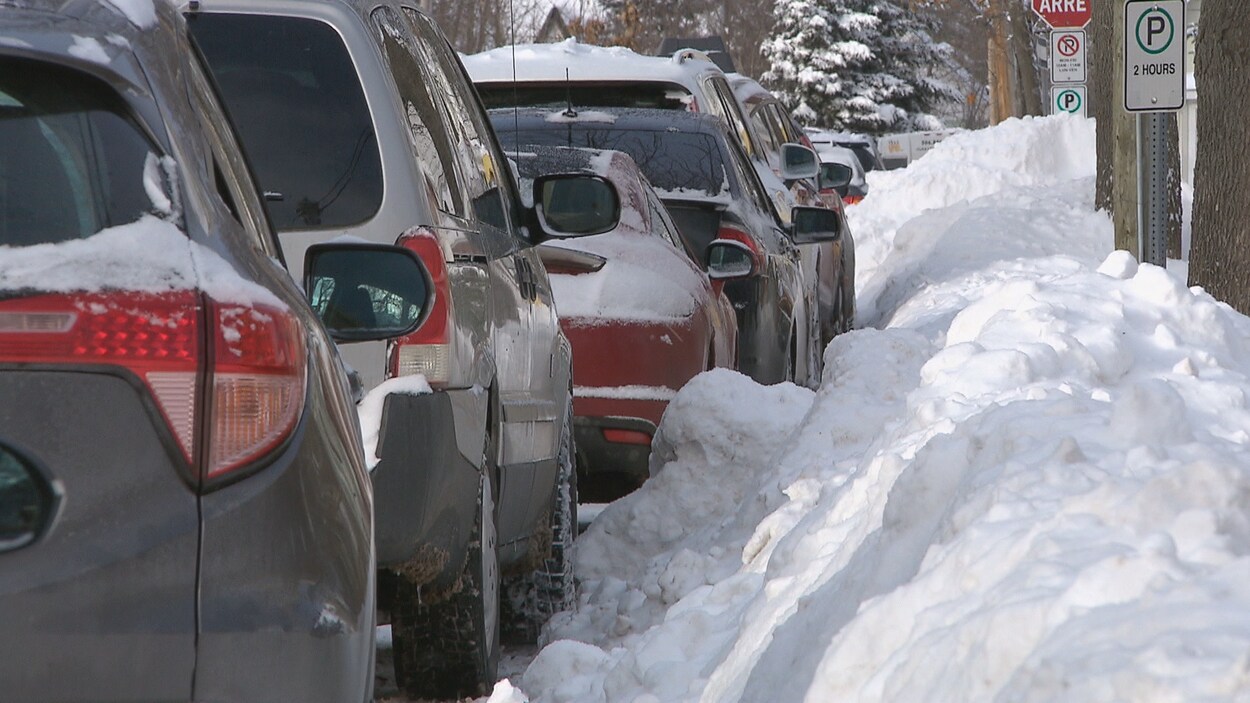 Des voitures garées le long d'une rue enneigée. Des voitures garées le long d'une rue enneigée.
