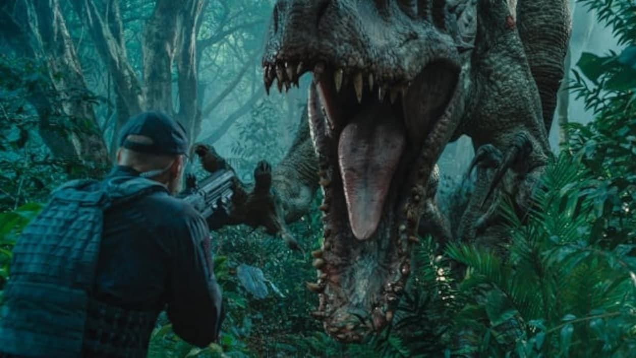 Un homme fait face à un dinosaure qui s'apprête à attaquer. Il a un fusil dans les mains.