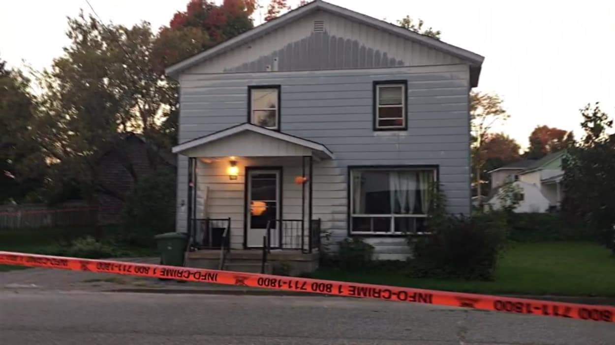 Une maison est entourée d'un ruban de sécurité de la police. Une maison est entourée d'un ruban de sécurité de la police.