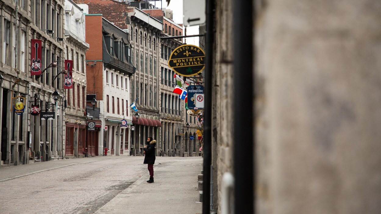 Un homme marche dans une rue déserte du Vieux-Montréal.