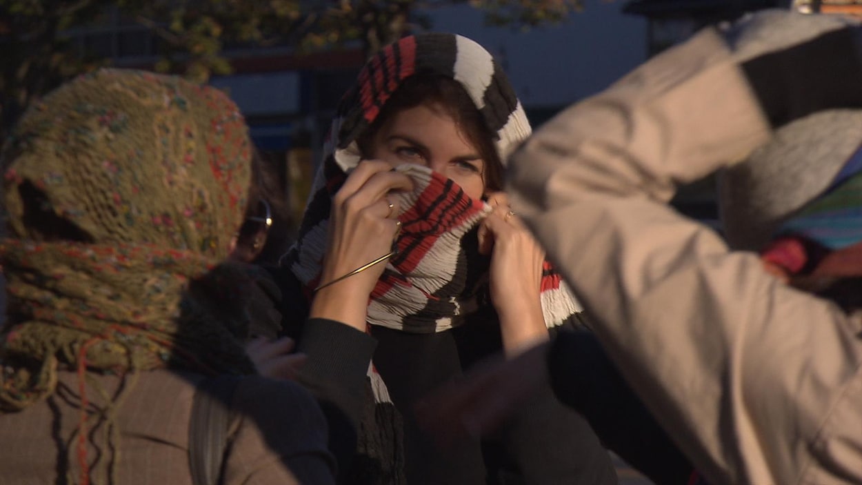 Des manifestants se sont masqués pour attendre l'autobus afin de protester contre la loi 62.