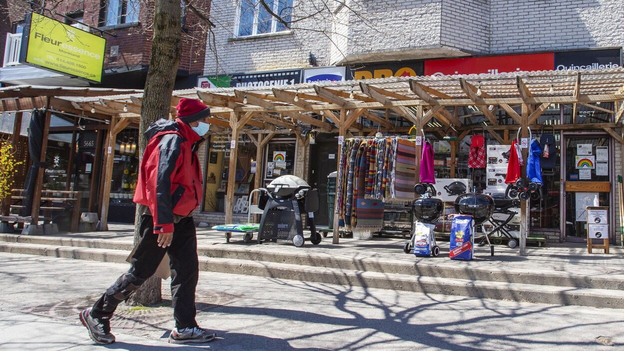 Un piéton marche devant des commerces.