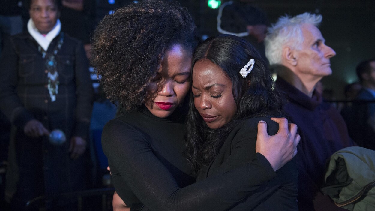 Deux femmes s'enlacent les yeux fermés.