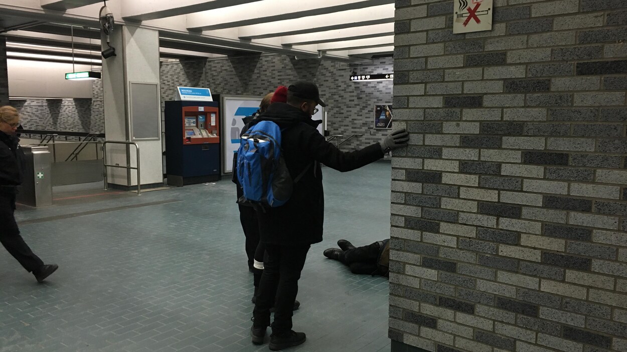 Les intervenants de PSI parlent à un itinérant dans le métro de Montréal