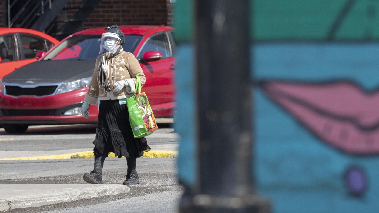 Une femme masquée marche dans l'arrondissement de Montréal-Nord.