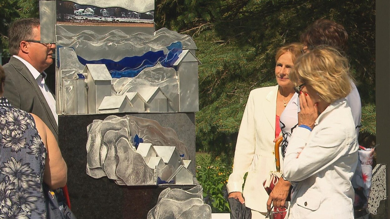 Des gens regardent un monument avec attention.
