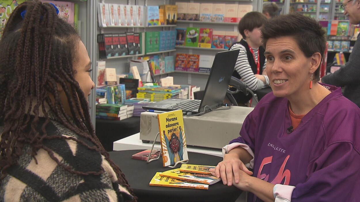 Morane Seni et Émilie Ouellette autour d'une table où se trouve le livre Morane adore parler !