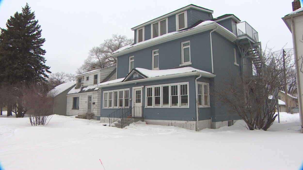 Une maison bleue et blanche l'hiver.