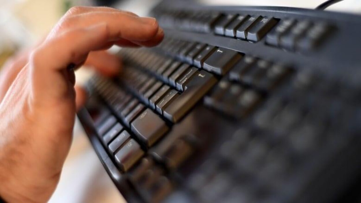 Une main tappe sur un clavier