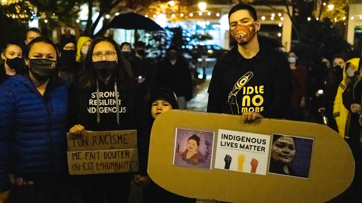 Des personnes rassemblées à une veillée aux chandelles devant l'hôtel de ville de Sherbrooke.