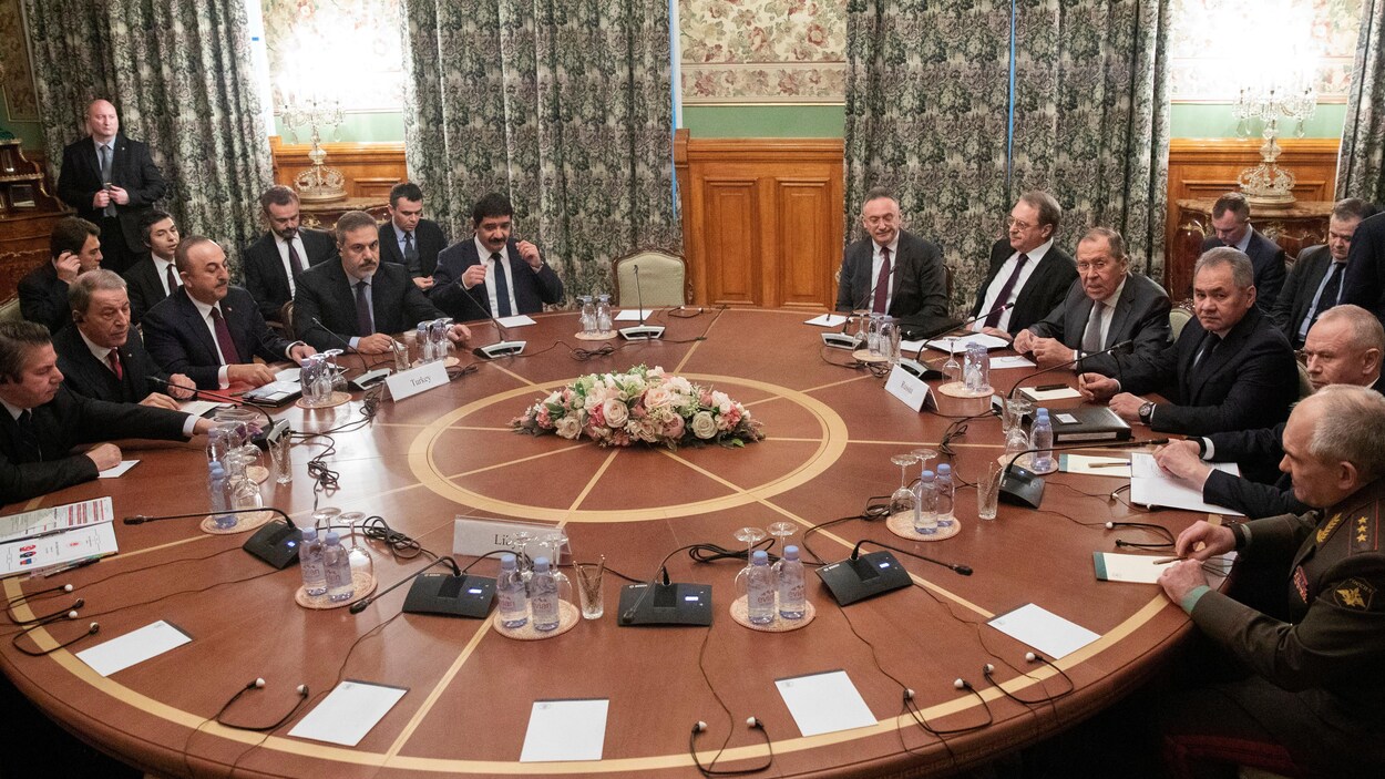 Des hommes autour d'une table ronde.