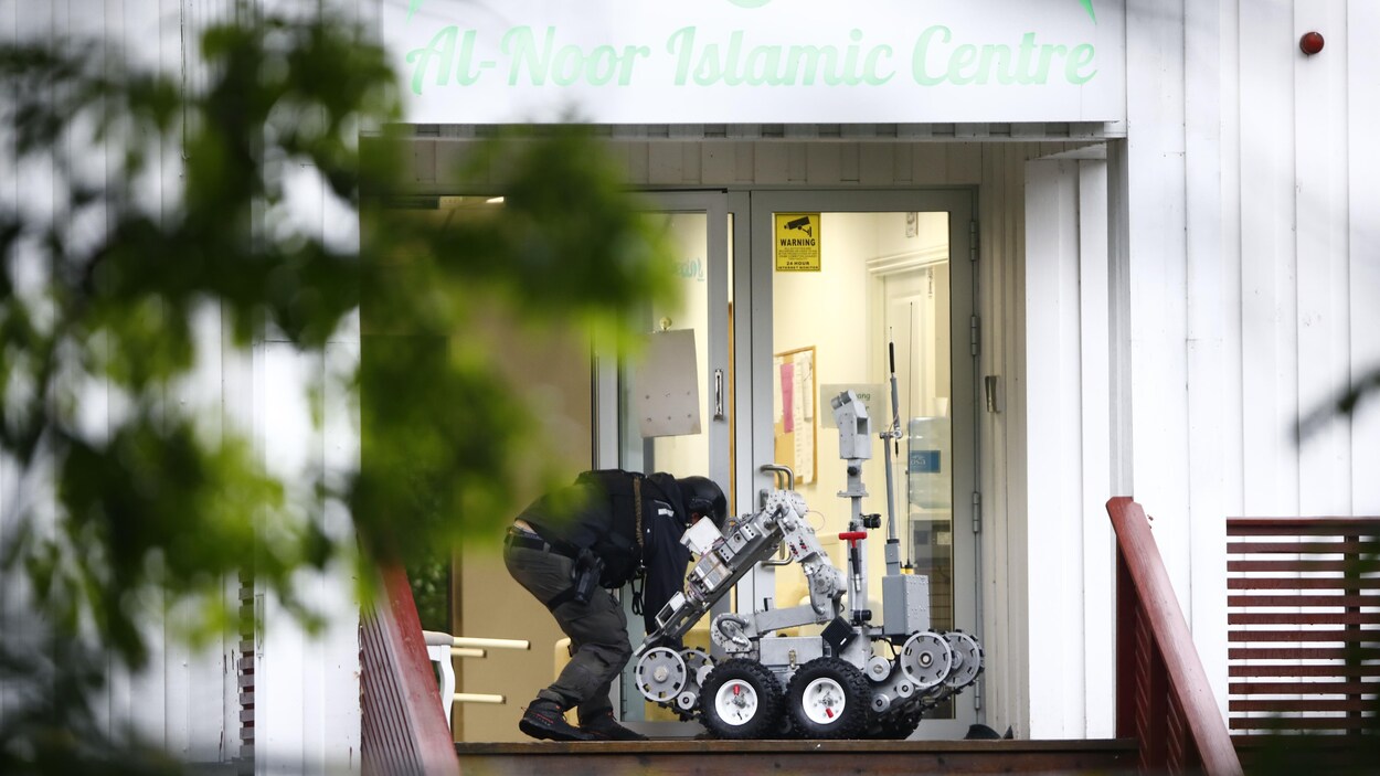 Un homme manipule un robot sur un perron.