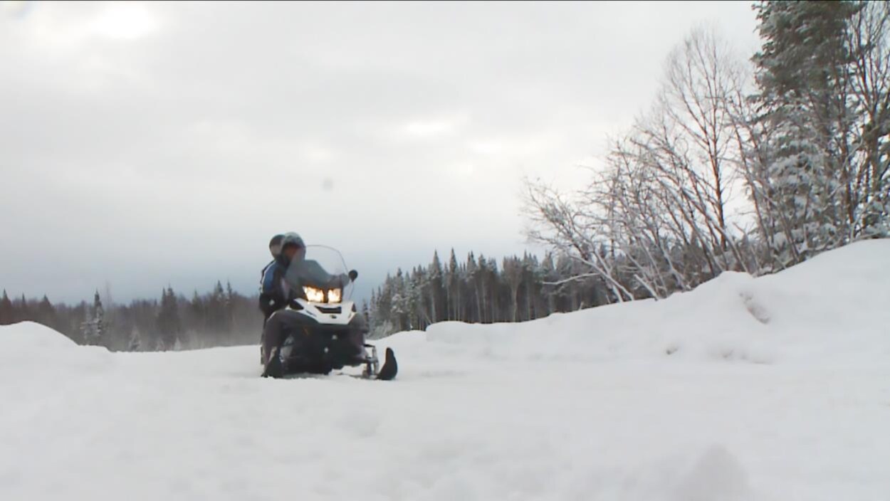 Une couple circule sur un sentier de motoneige de la Côte-Nord Une couple circule sur un sentier de motoneige de la Côte-Nord