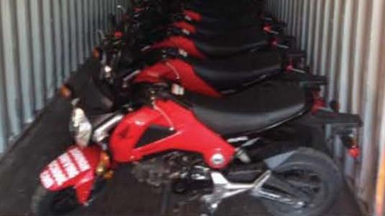 Une succession de motos rouges entreposées dans une remorque.