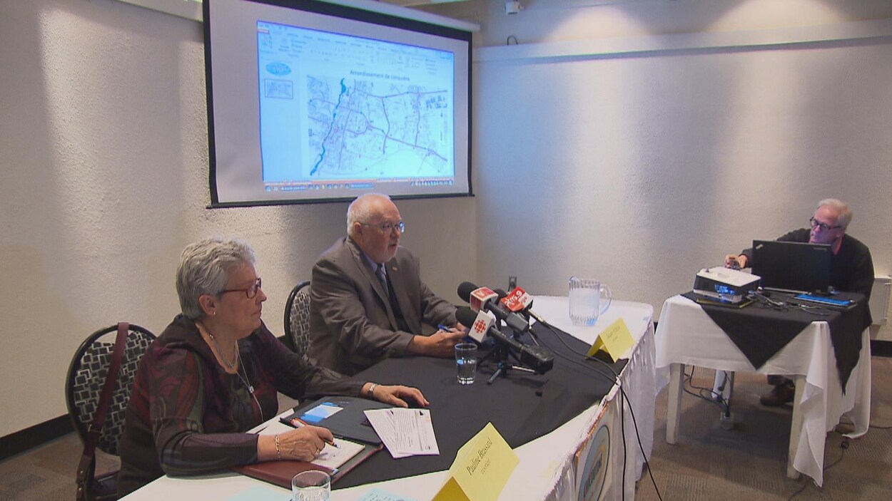 Des membres du Mouvement Chicoutimi assis, dos à un projecteur Des membres du Mouvement Chicoutimi assis, dos à un projecteur