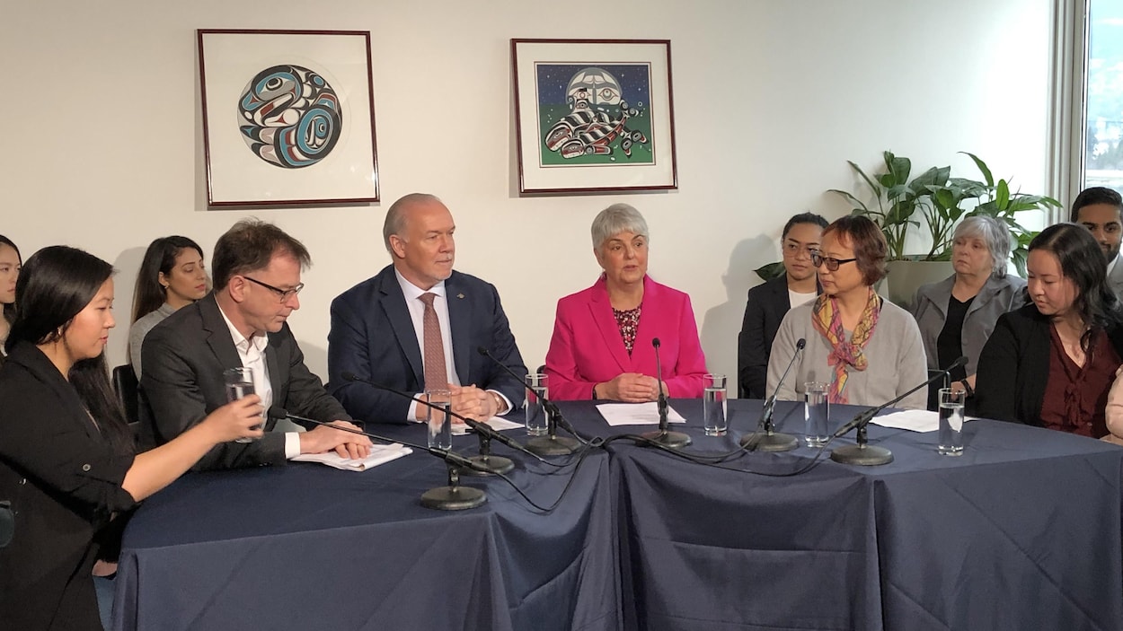 Plusieurs intervenants, dont John Horgan, Carol James et Adrian Dix sont assis derrière une table.