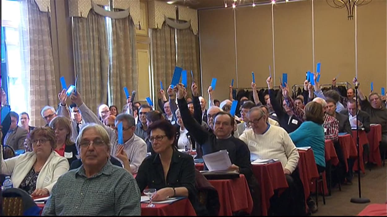 Des représentants de municipalité tendent un bulletin bleu en signe d'approbation.